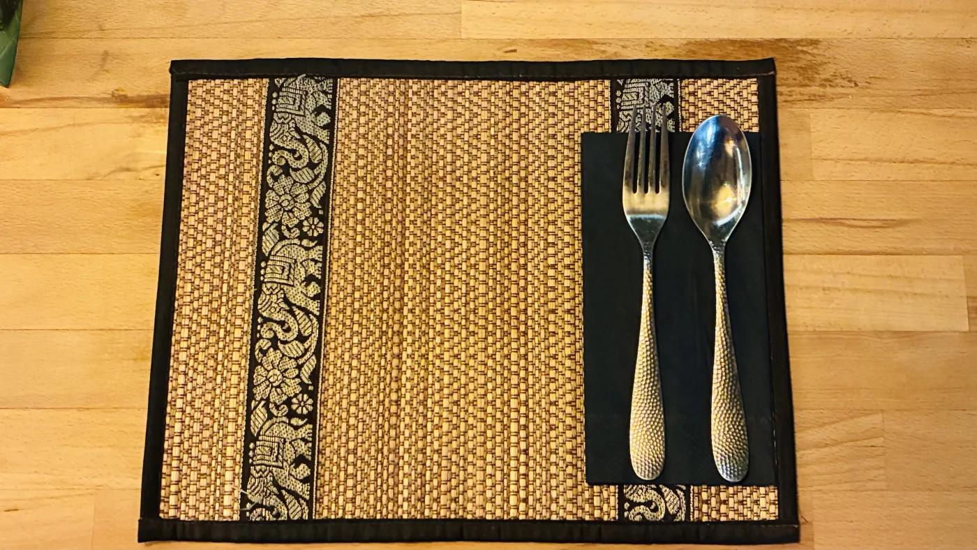 Thai place setting with woven mat and cutlery