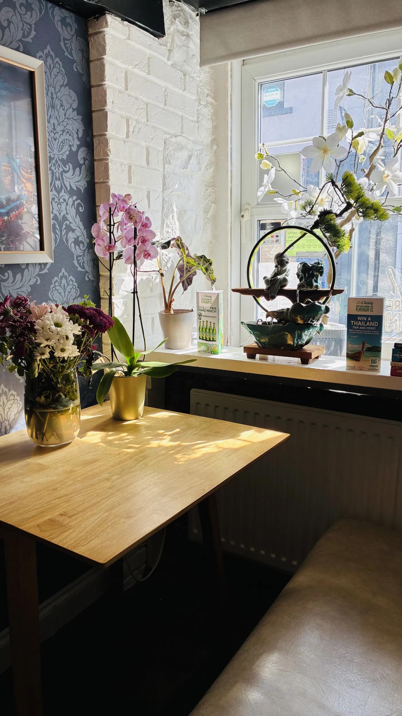 Table by the window with fresh orchids